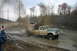 1989 Ford Bronco - A lifted Ford pickup truck powers through a muddy track, sending dirt flying.
