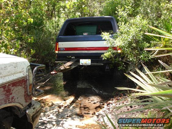 Ford Bronco stuck in mud, another truck nearby
