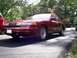 1995 Ford Crown Victoria - A red 1995 Ford Crown Victoria sedan is viewed from a three-quarter front angle on a sunny day.