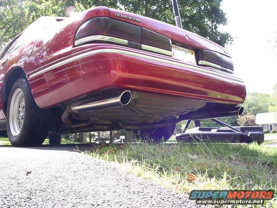Red 1995 Ford Crown Victoria rear view with dual exhaust pipes