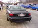 1995 Ford Crown Victoria - A black sedan with a 'Marauder' badge is parked on the side of the road, with other vehicles in the background.