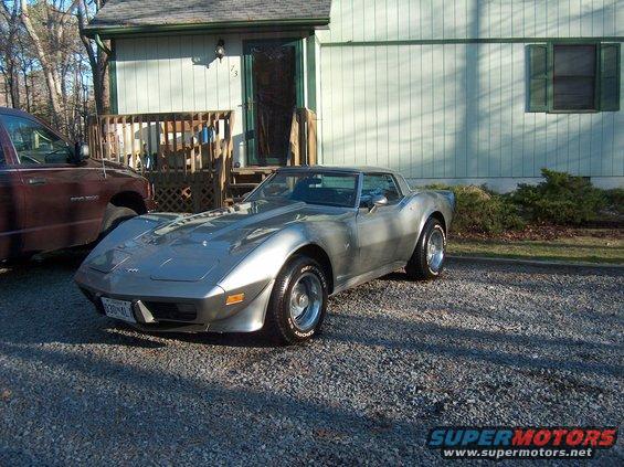 Silver Chevrolet Corvette parked on gravel, front 3/4 view. License plate reads '630-ML'