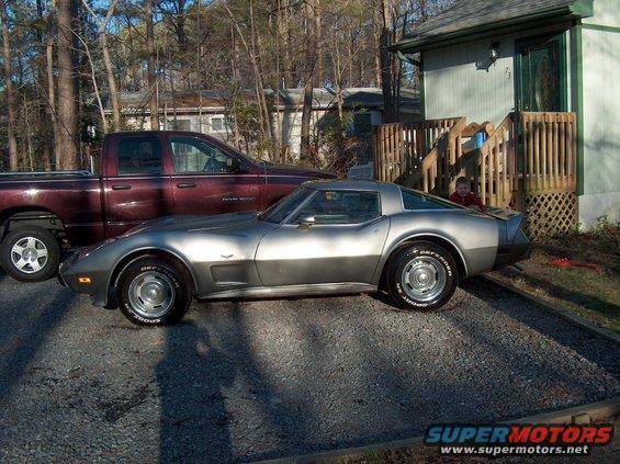 Silver sports car parked next to a maroon pickup truck in a driveway
