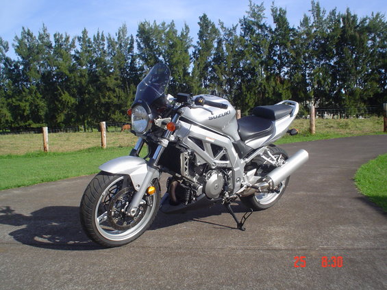 Silver motorcycle with a dark windscreen and a prominent exhaust pipe