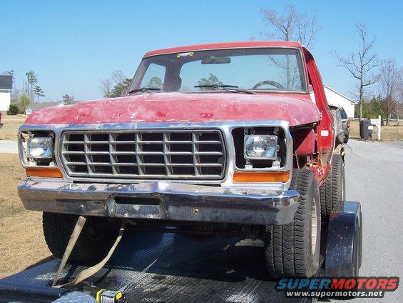 Front view of a red 1979 Ford F-150 pickup truck on a trailer