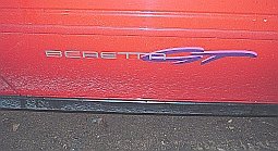 Red car door with 'BERETTA' emblem and a purple stylized graphic