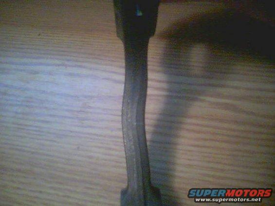 Bent metal connecting rod on wooden surface
