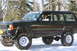 1995 Jeep Cherokee - A lifted Jeep Cherokee sits in a snowy, wooded area with a person inside.