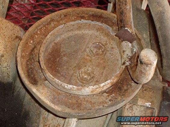 Close-up of a rusty coil spring and mounting hardware