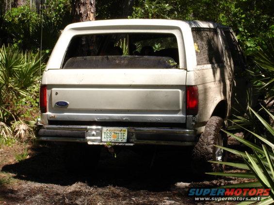 1989 Ford Bronco rear view, stuck in dirt with vegetation around