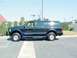 2003 Ford Excursion - This black 2003 Ford Excursion SUV is seen from the side, equipped with a roof rack.