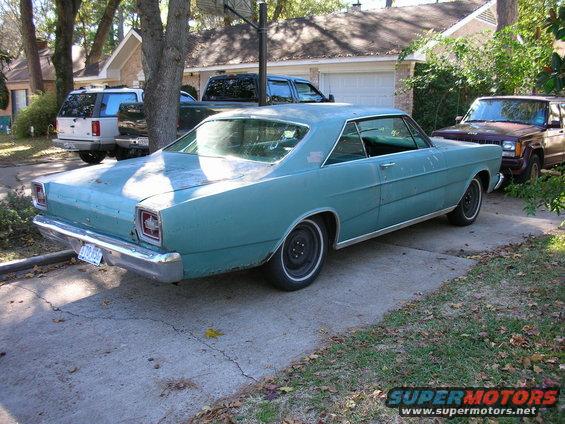Teal 1966 Ford Galaxie coupe parked in driveway, rear 3/4 view