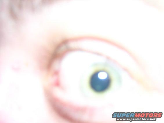 Close-up of a person's eye with a watermark for supermotors.net at the bottom right
