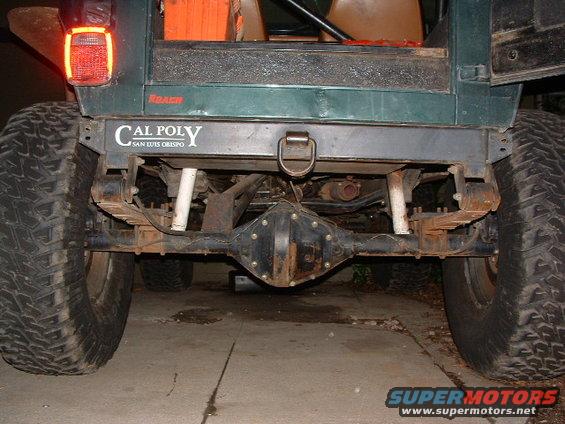Rear view of a Jeep showing its axle, leaf springs, and large tires. Has a 'Cal Poly San Luis Obispo' sticker