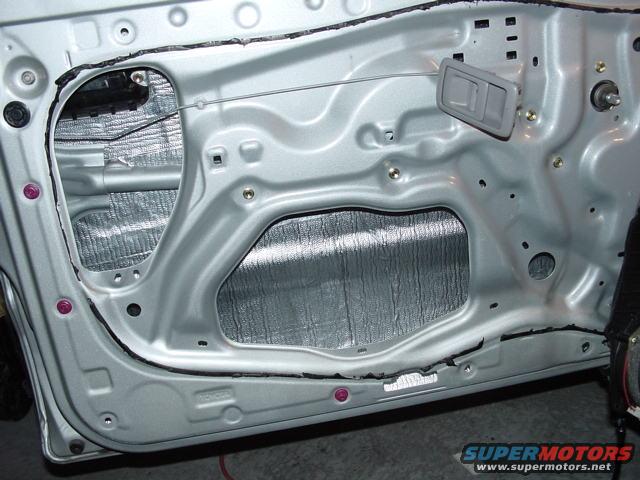 Interior door panel with silver sound deadening material applied