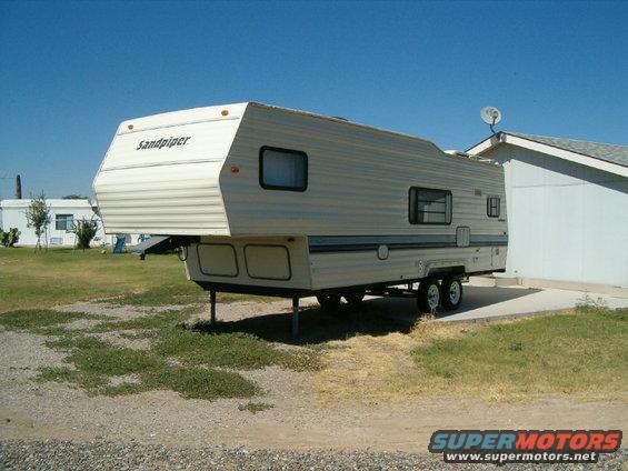 Fifth wheel trailer parked next to a house