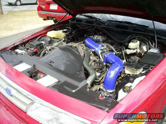 1995 Ford Crown Victoria engine bay with custom blue intake pipes and modified air intake