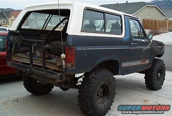 1986 Ford Bronco lifted with large off-road tires, viewed from the rear quarter