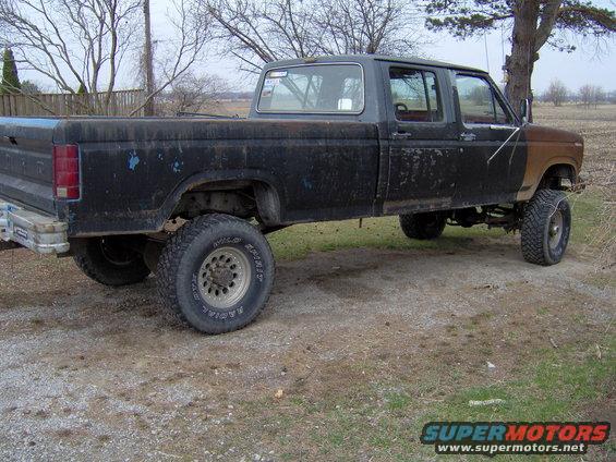 Black Ford F-350 crew cab pickup truck with lifted suspension and aftermarket wheels, parked outdoors