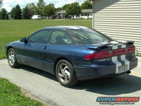 Blue coupe with white racing stripes parked on asphalt