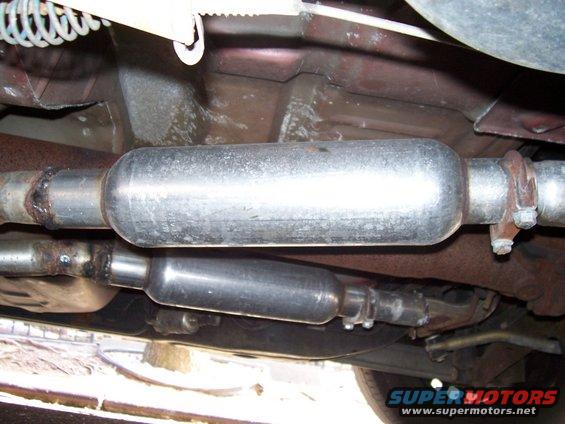 Underside view of two mufflers and exhaust pipes, one above the other