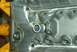 1990 Ford Mustang - Close-up of an engine block a metal tube fitting and the Supermotors.net watermark.