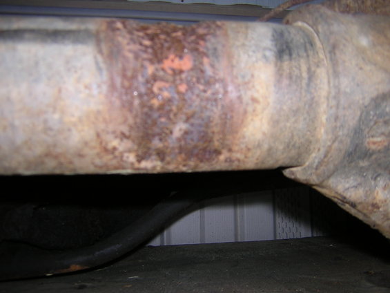 close-up of a rusty metal pipe, possibly part of a vehicle's exhaust or suspension system