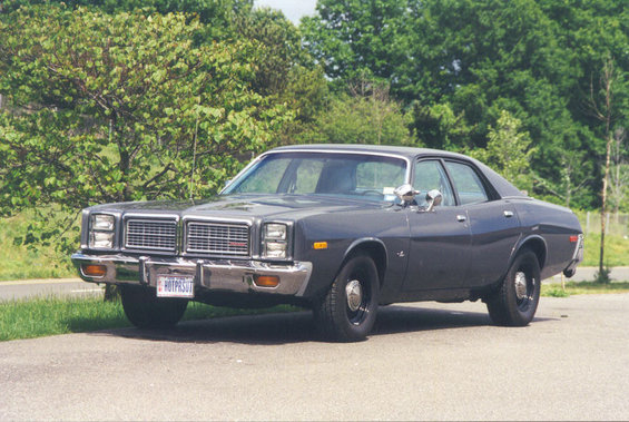 Dark gray sedan, 3/4 front view. License plate reads HOTPASUT