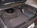 1978 Dodge Monaco - The trunk of a car contains a spare tire and an aftermarket amplifier.