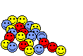Pile of red, yellow, and blue smiley faces on a green background