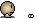 Pixelated smiley face with a light bulb head against a dark, speckled background