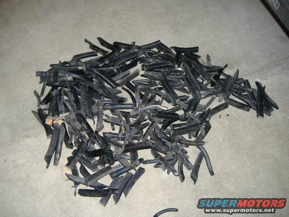 Pile of black rubber trim pieces on a concrete floor