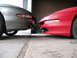 1996 Ford Probe - The front ends of two cars are positioned very close to each other in a garage setting.
