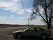 1996 Ford Probe - A silver 1996 Ford Probe coupe is parked on a gravel shoulder next to a rural road.