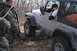 1995 Jeep Cherokee - A silver Jeep Wrangler is stuck in the mud, with several people attempting to help.