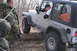 1995 Jeep Cherokee - A silver Jeep Wrangler navigates an obstacle during an off-road excursion with onlookers present.
