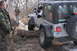 1995 Jeep Cherokee - A Jeep Wrangler navigates an off-road obstacle, with a driver and passenger inside.