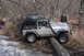 1995 Jeep Cherokee - A silver Jeep Wrangler Rubicon is shown off-roading through a wooded area with a snorkel and roof rack.