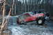 1995 Jeep Cherokee - A red Jeep Wrangler is stuck in icy mud, with another vehicle visible in the background.