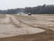 2004 Dodge 2500 - Multiple vehicles travel down a dirt track, kicking up dust under an overcast sky.