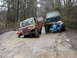 2004 Dodge 2500 - Two off-road vehicles are stuck in the mud on a dirt road, with people attempting to free one of them.
