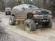 2004 Dodge 2500 - A heavily modified 1995 Ford Explorer navigates a muddy trail, with another off-road vehicle visible behind it.