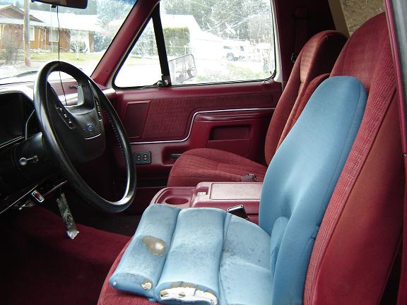 1990 Ford Bronco interior showing maroon seats, steering wheel, and dashboard