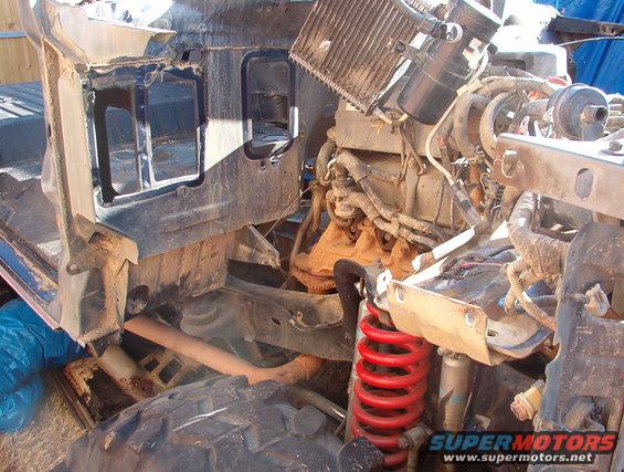 1994 Ford Bronco chassis with engine and suspension parts visible, undergoing disassembly