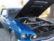 1969 Ford Mustang - A blue 1969 Ford Mustang is shown with its hood open, revealing the engine bay and air intake system.