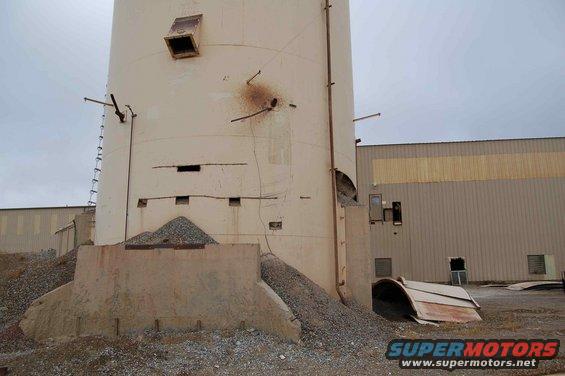 Industrial silo with debris and corrugated metal building