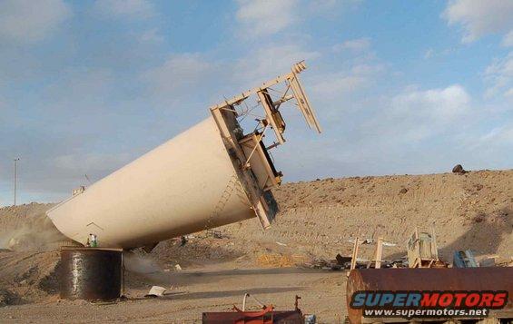 Fallen industrial silo in a desert landscape with construction debris