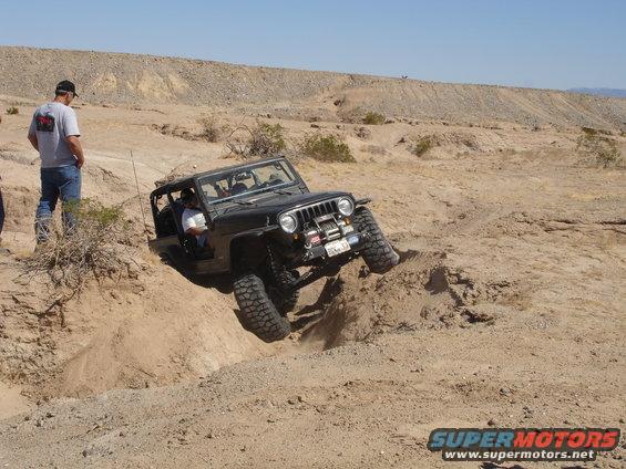 Black Jeep Wrangler climbing a steep dirt embankment