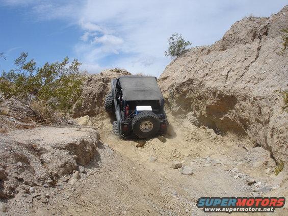 Black off-road SUV climbing a rocky hill