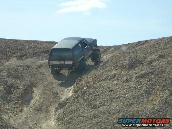Black 1996 Ford Bronco climbing a steep, rocky hill off-road